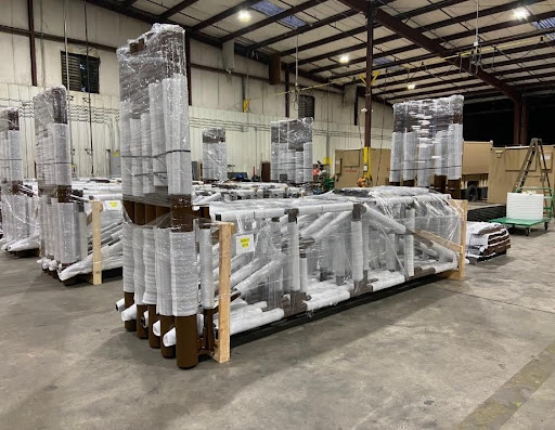 2.	Industrial metal structures awaiting further processing, are lined up on a concrete floor.